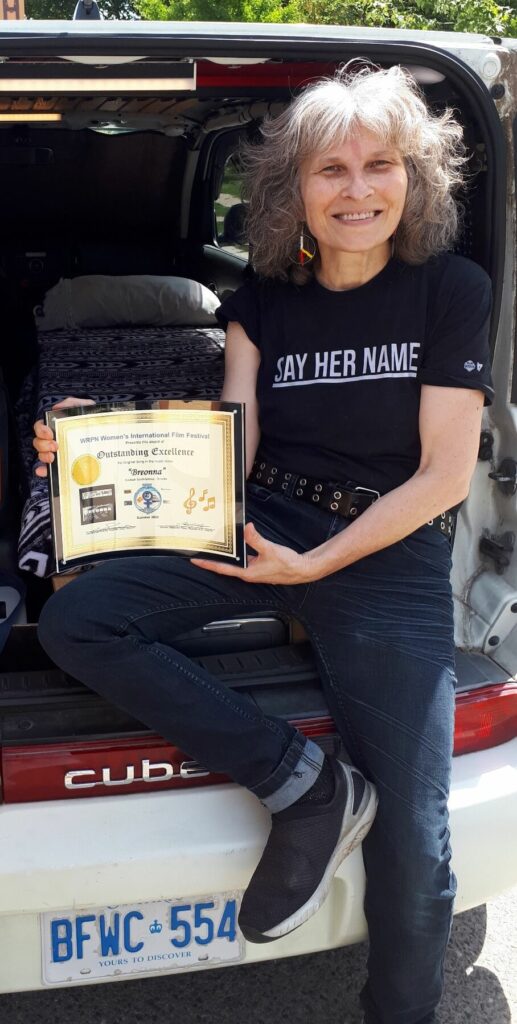 Anna with the Outstanding Excellence in Original Song award from WRPN Women's International Film Festival. Photo taken by Bryn Scott-Grimes at his Cube Studios van.